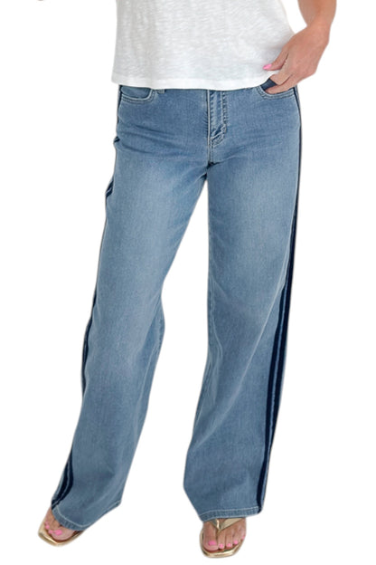 Front view of woman wearing Swagger Boutique’s Medium Wash Tuxedo Stripe Jeans by Just Black Denim with white top against white studio background.