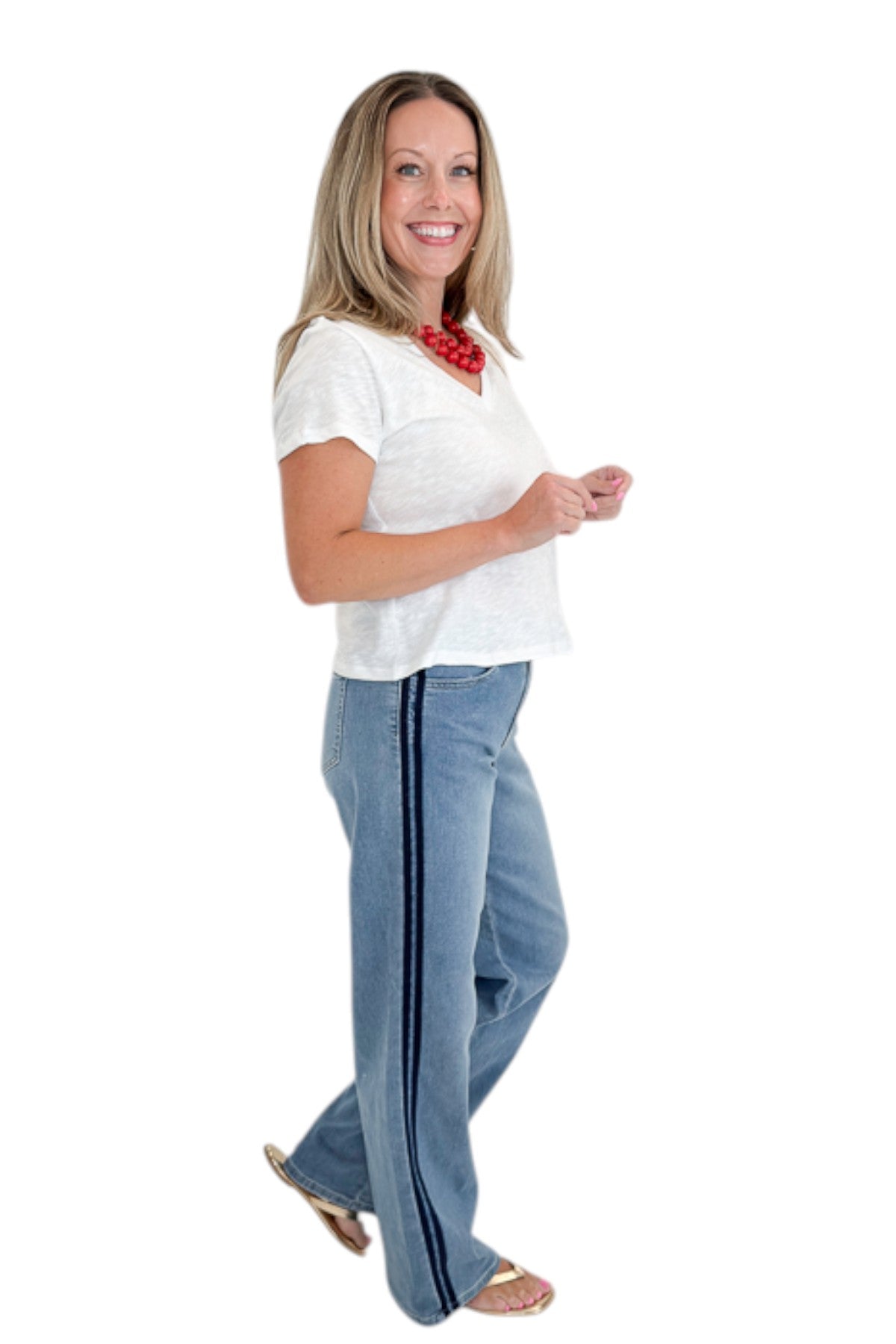 Side view of woman wearing Swagger Boutique’s Medium Wash Tuxedo Stripe Jeans by Just Black Denim with white top against white studio background.
