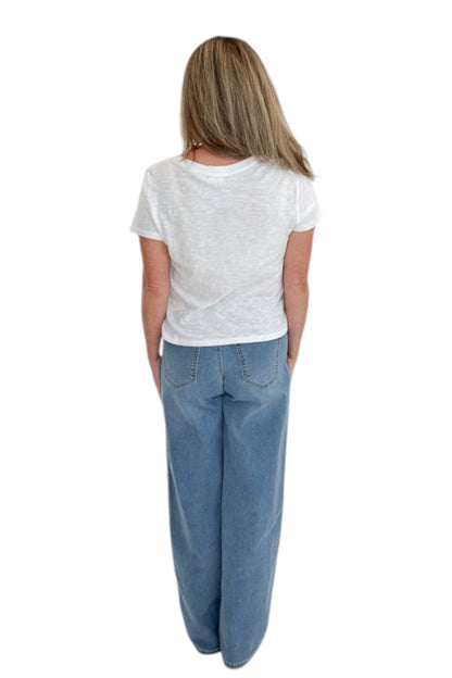 Back view of woman wearing Swagger Boutique’s Medium Wash Tuxedo Stripe Jeans by Just Black Denim with white top against white studio background.