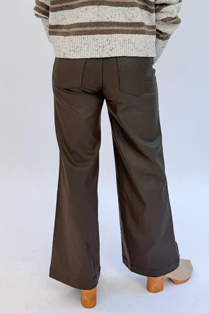 Back view of woman wearing Swagger Boutique’s sweater with Meg Coated Wide Leg Jeans in Toffee by Kut from the Kloth against white studio background.