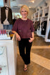 Front view of woman standing at Swagger Boutique wearing Merlot Suede Horsebit Pocket Top by Entro with jeans. 