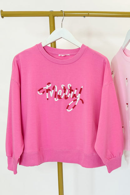 Millie Merry Corded Holiday Sweatshirt hanging on a rack against a white background.
