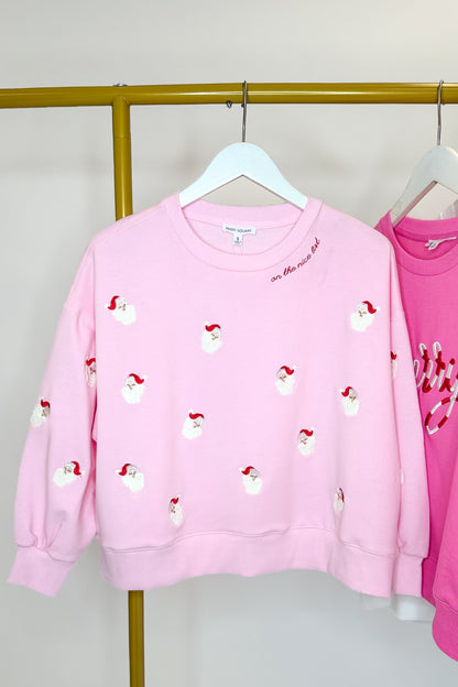 Millie Small Santas Sweatshirt hanging on a rack.