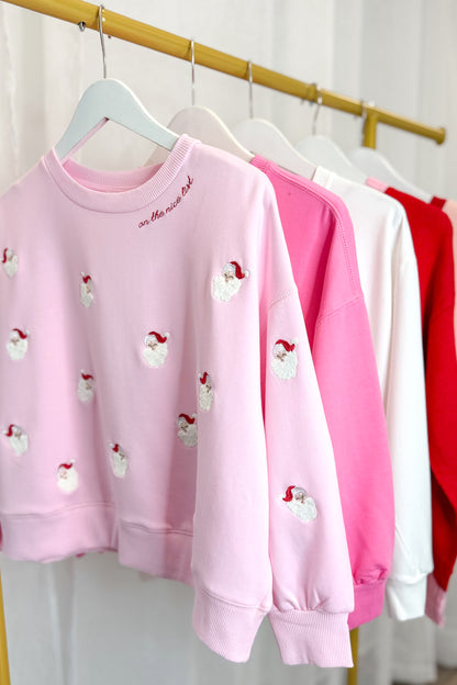 Millie Small Santas Sweatshirt hanging on a rack.
