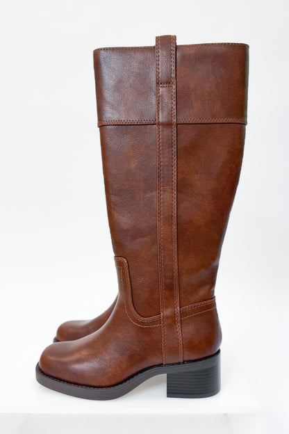 Mizell- Brown Tall Boots against white studio background side view.