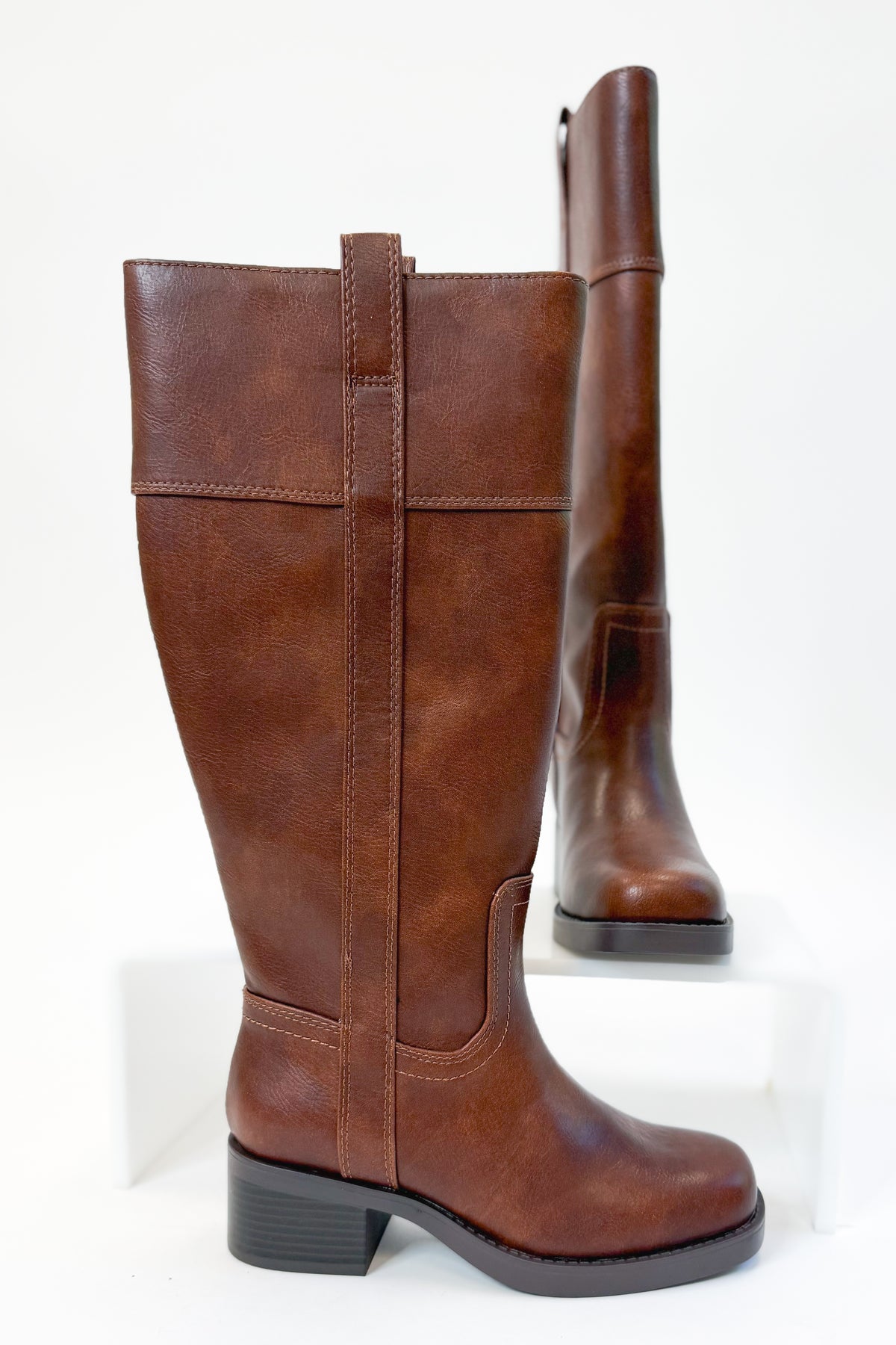 Mizell- Brown Tall Boots against white studio background side view.