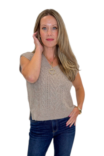 Front view of woman wearing Swagger Boutique’s Mocha Cable Knit V-neck Sweat Vest with jeans against white studio background.