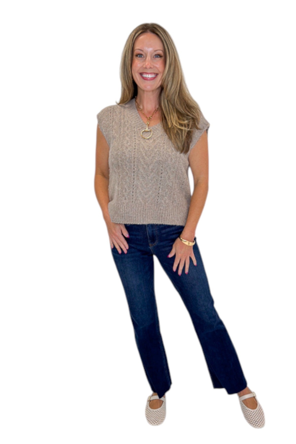 Front view of woman wearing Swagger Boutique’s Mocha Cable Knit V-neck Sweat Vest with jeans against white studio background.