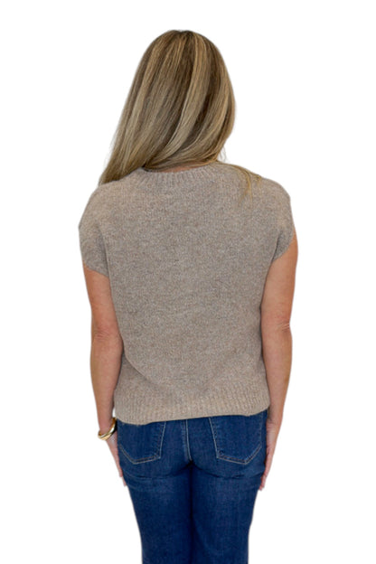 Back view of woman wearing Swagger Boutique’s Mocha Cable Knit V-neck Sweat Vest with jeans against white studio background.