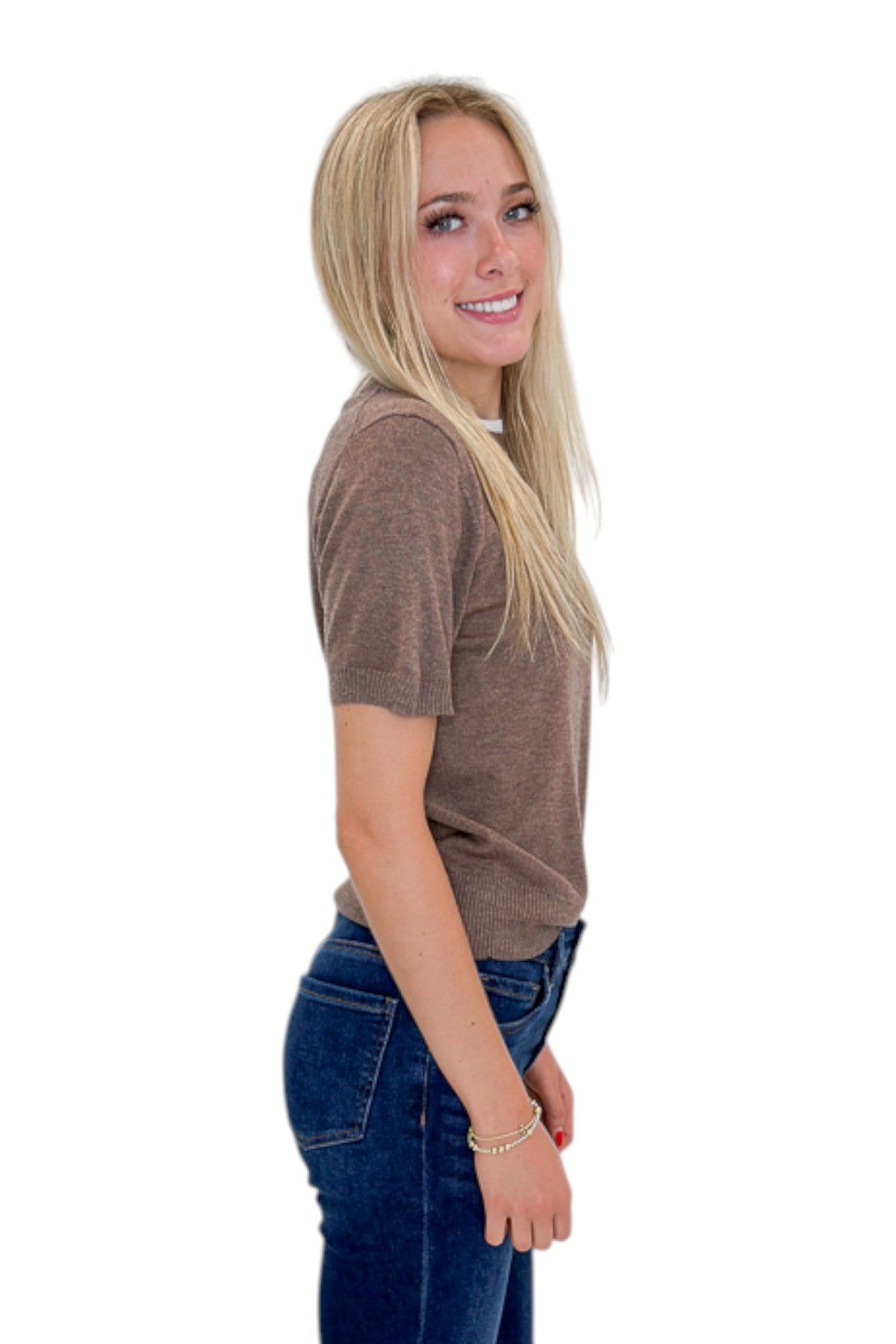 Side view of woman wearing Swagger Boutique’s Mocha Double Collared Top with jeans against white studio background.