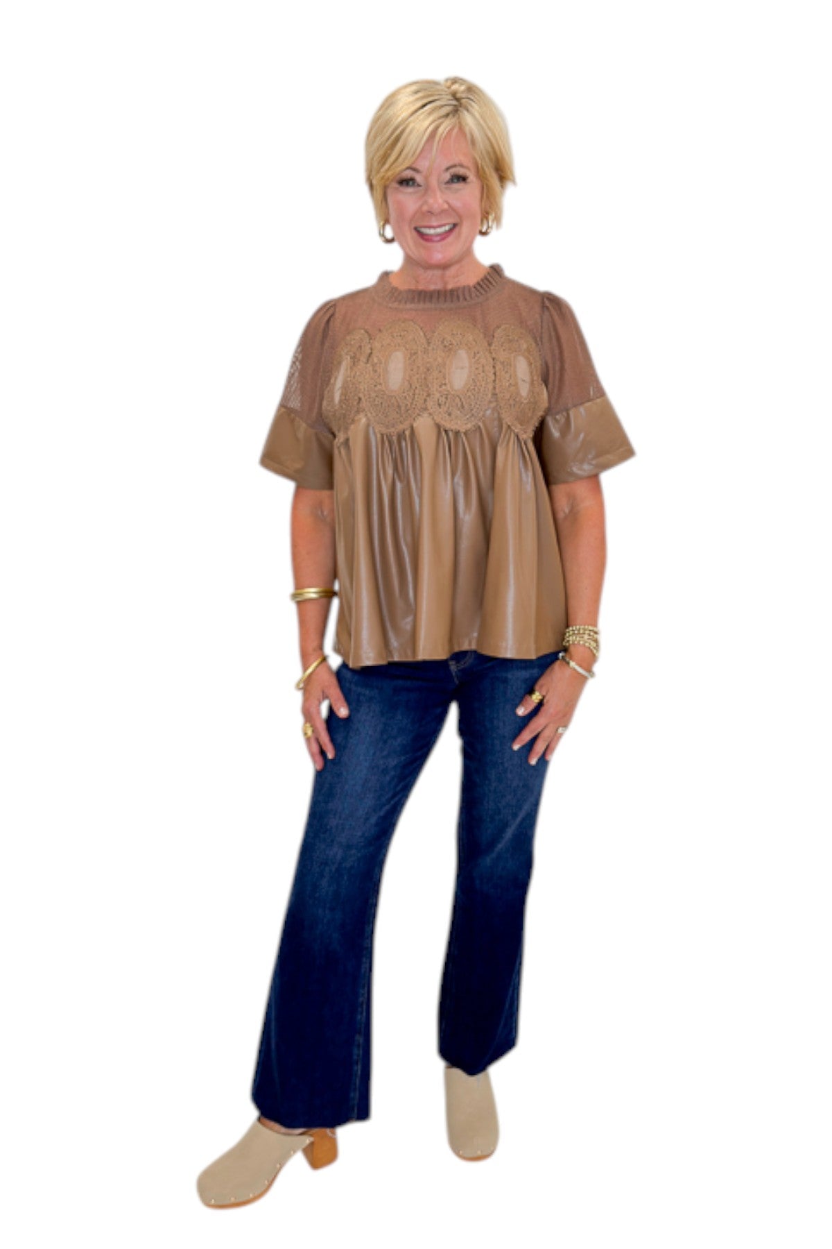 Front view of woman wearing Swagger Boutique’s Mocha Lace Applique Faux Leather Top with jeans against white studio background.