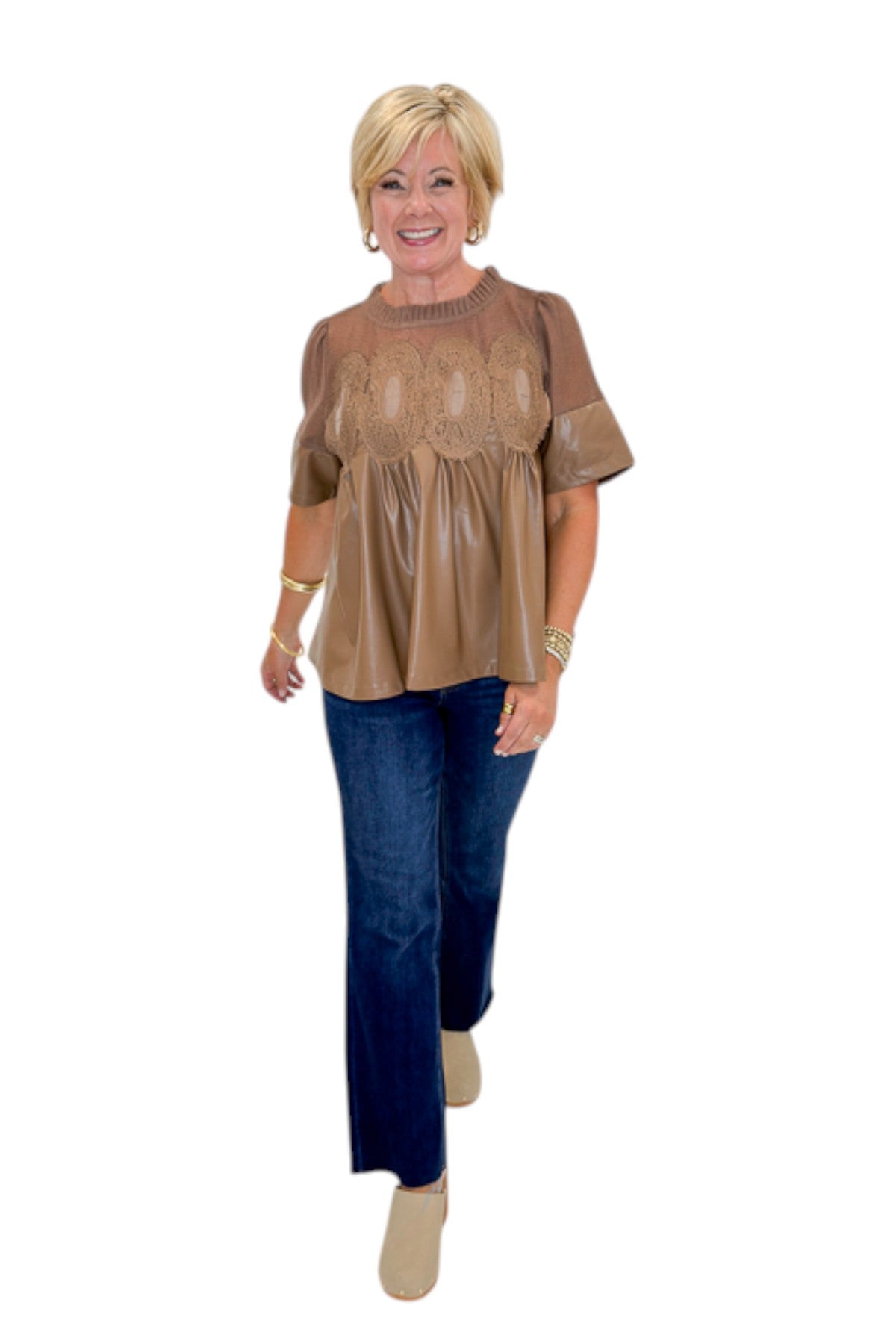 Front view of woman wearing Swagger Boutique’s Mocha Lace Applique Faux Leather Top with jeans against white studio background.