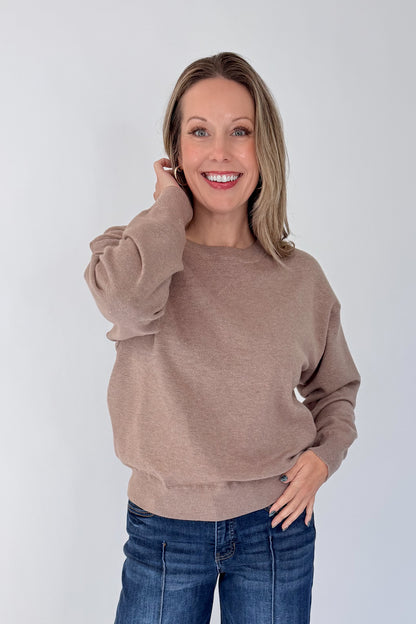 Front view of woman wearing Swagger Boutique’s Mocha Ribbed Hem Sweatshirt with jeans against white studio background.
