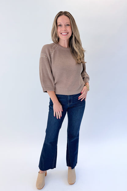 Front view of woman wearing Swagger Boutique’s Mocha Stud Detail Sweater by Entro with jeans against white studio background.