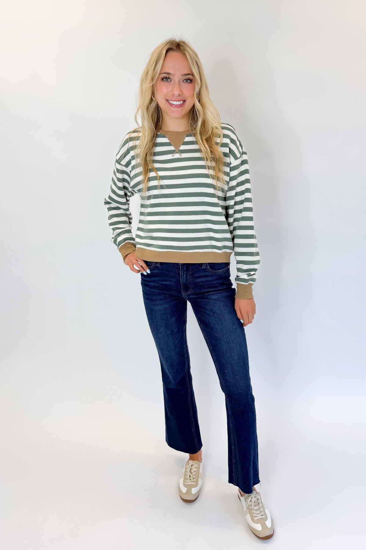 Front view of woman wearing Swagger Boutique’s Monstera Low Key Stripe Sweatshirt by Z Supply with jeans against white studio background.