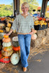 Front view of woman wearing Swagger Boutique’s Monstera Low Key Stripe Sweatshirt by Z Supply with jeans standing at a pumpkin patch.