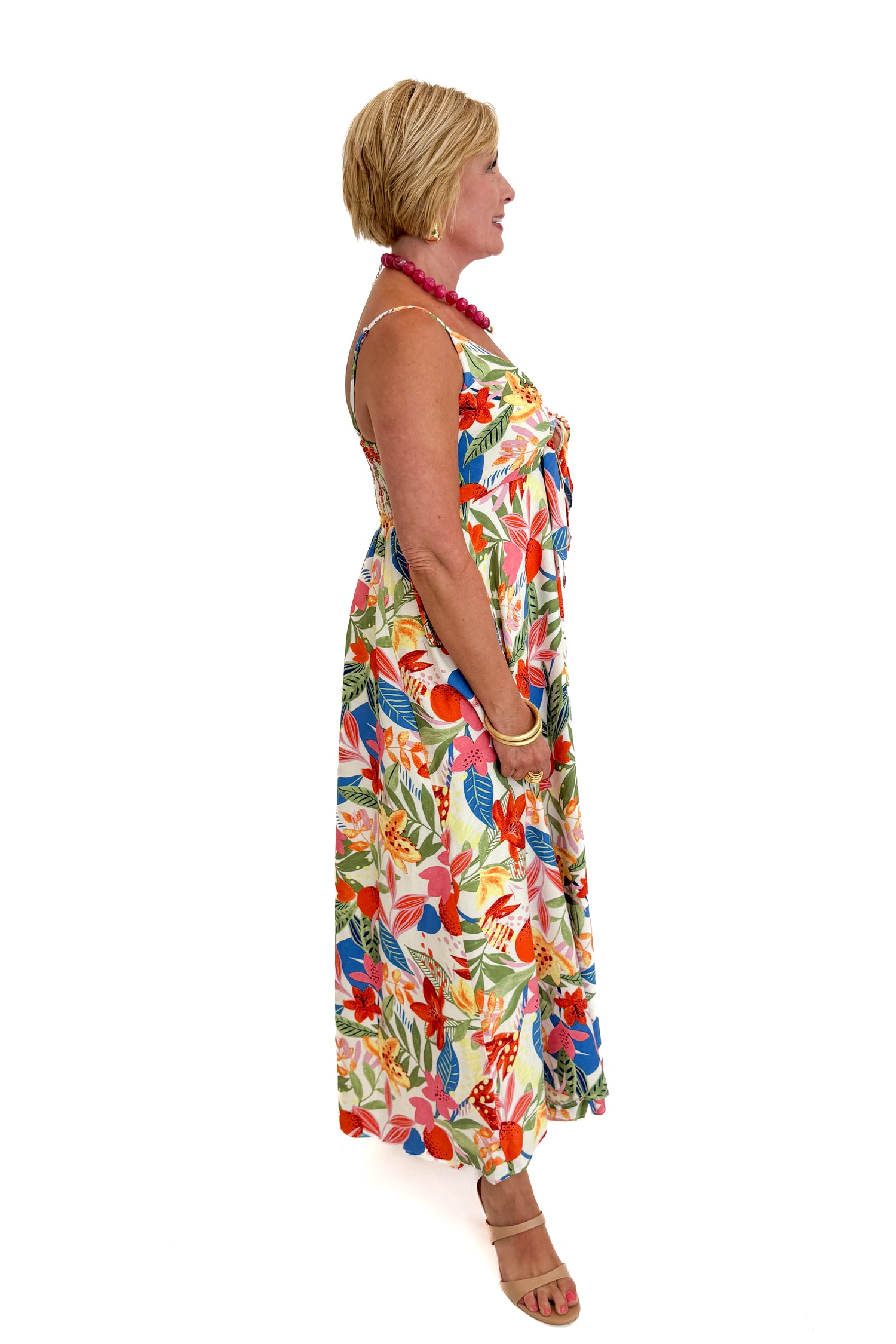 Side view of woman wearing Swagger Boutique’s Multi Floral Midi Dress against white studio background.