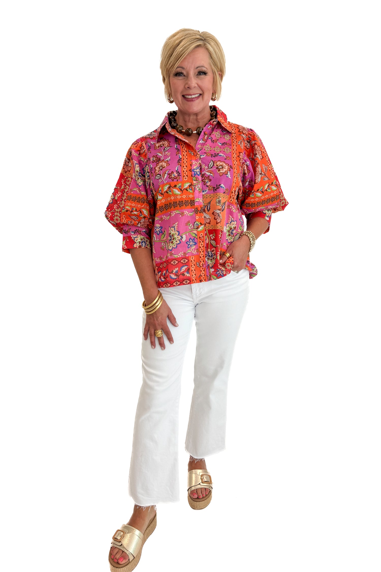 Front view of woman wearing Swagger Boutique’s Multi Floral Patchwork Top with jeans against white studio background.