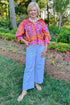 Front view of woman wearing Swagger Boutique’s Multi Floral Patchwork Top with jeans standing outside.