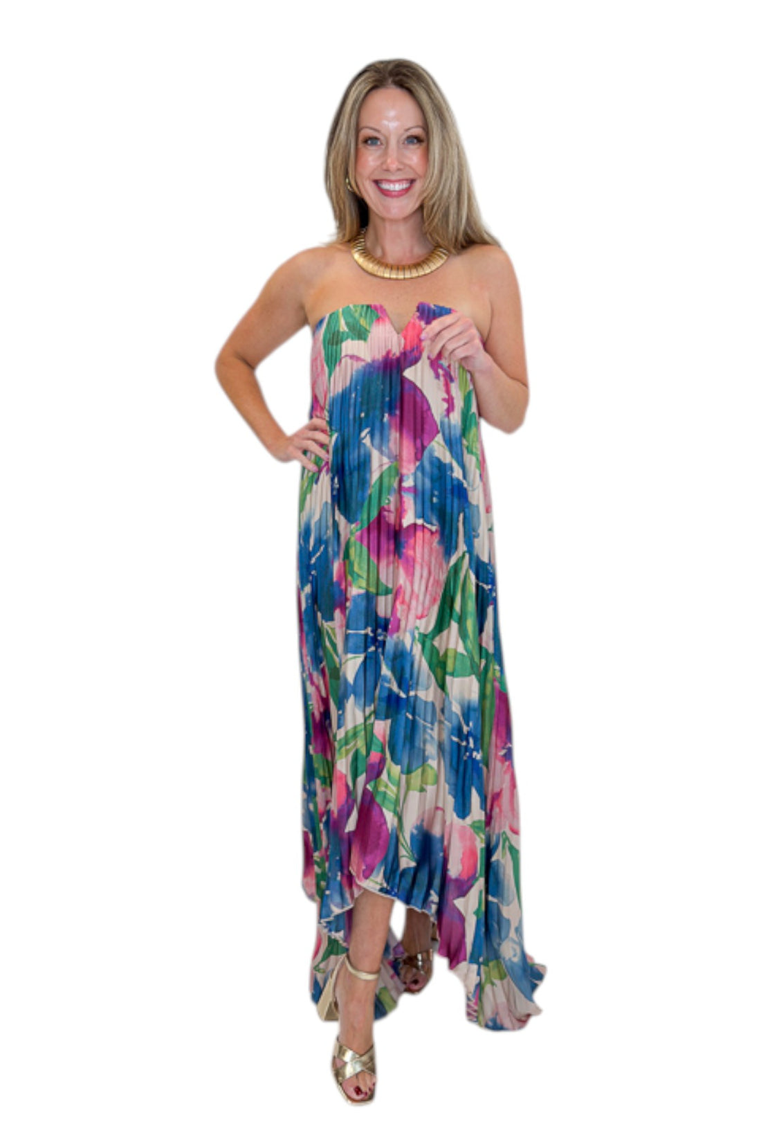 Front view of woman wearing Swagger Boutique’s Multi Floral Pleated Maxi Dress with heels against white studio background.