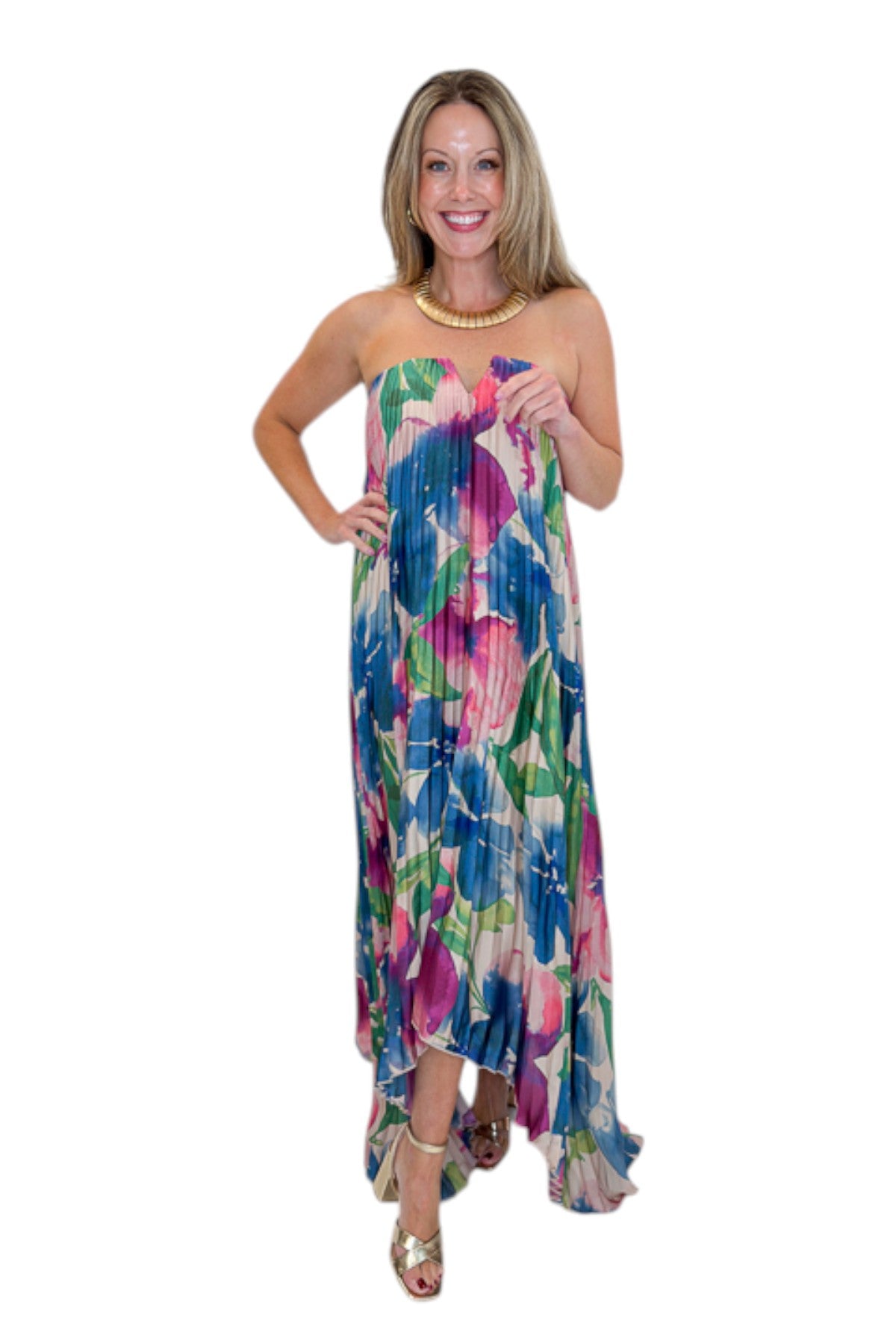 Front view of woman wearing Swagger Boutique’s Multi Floral Pleated Maxi Dress with heels against white studio background.