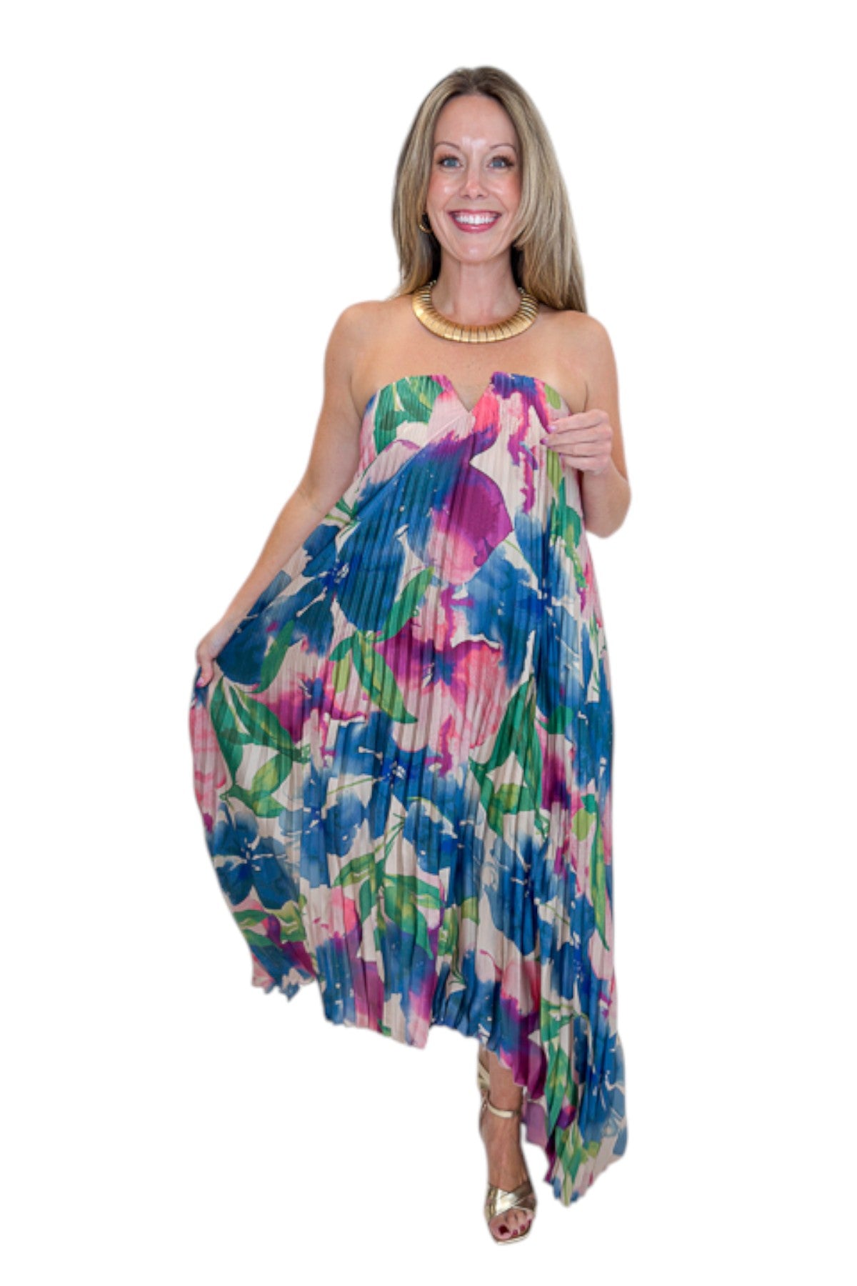 Front view of woman wearing Swagger Boutique’s Multi Floral Pleated Maxi Dress with heels against white studio background.