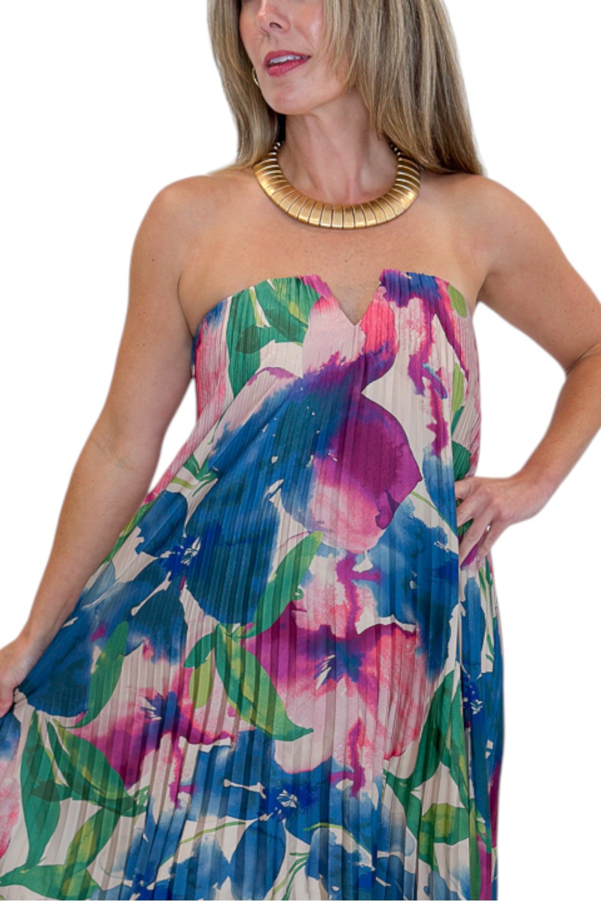 Front detail view of woman wearing Swagger Boutique’s Multi Floral Pleated Maxi Dress with heels against white studio background.