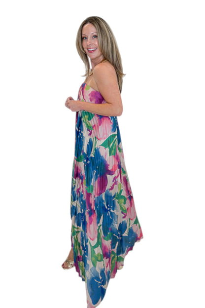 Side view of woman wearing Swagger Boutique’s Multi Floral Pleated Maxi Dress with heels against white studio background.