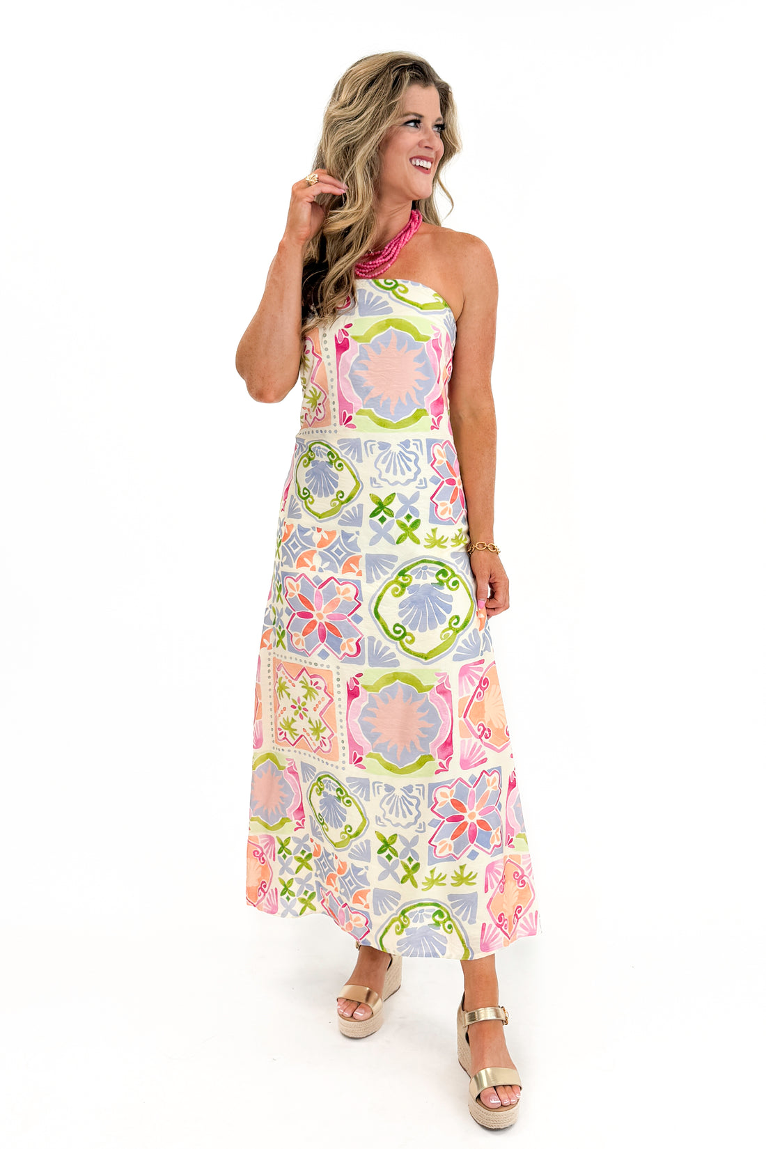 Front view of woman wearing Swagger Boutique’s Multi Printed Strapless Midi Dress with sandals against white studio background.