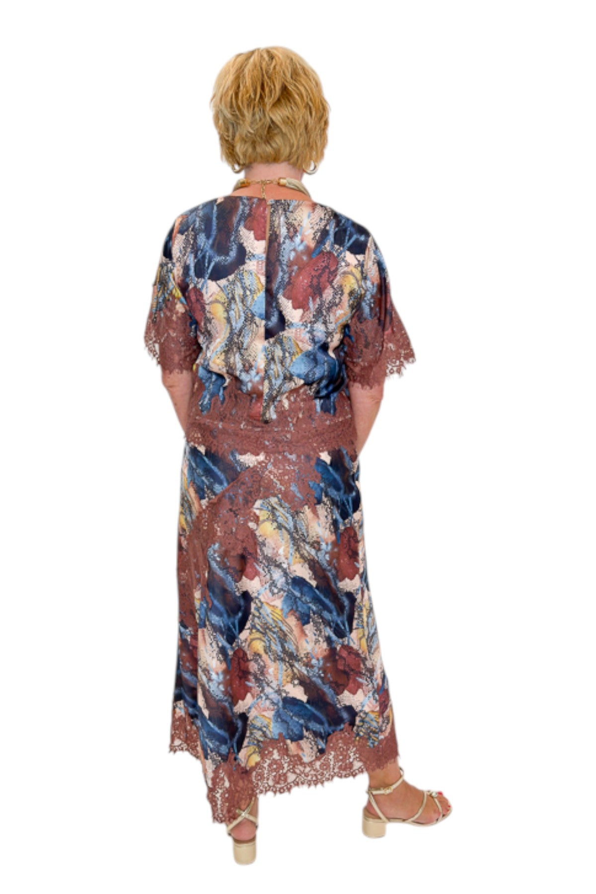 Back view of woman wearing Swagger Boutique’s Multi Snake Print Lace Trim Top with Multi Snake Print Lace Trim Midi Skirt against white studio background.