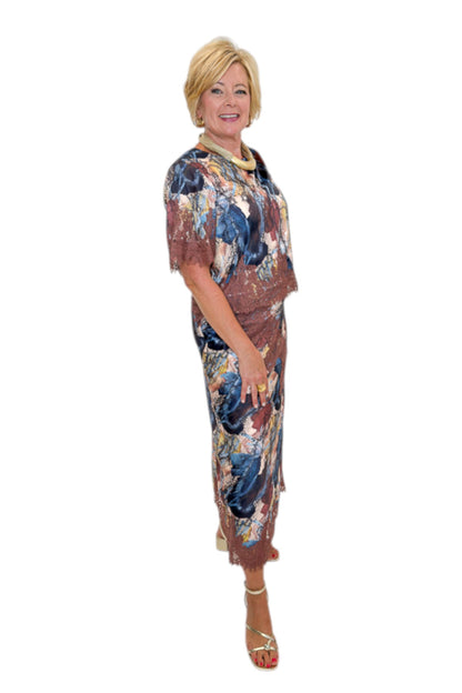 Side view of woman wearing Swagger Boutique’s Multi Snake Print Lace Trim Top with Multi Snake Print Lace Trim Midi Skirt against white studio background.