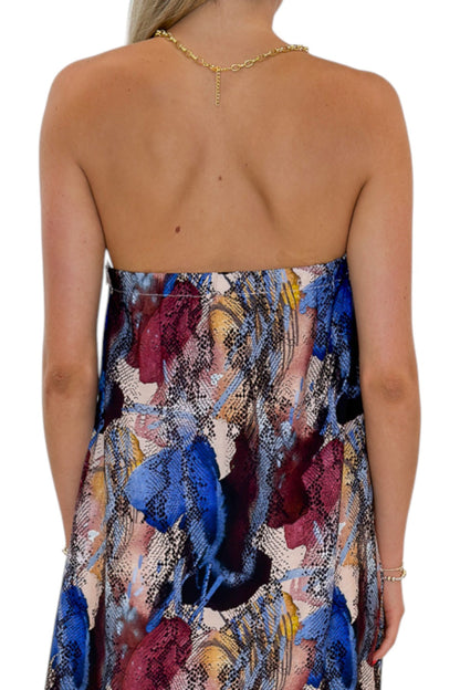 Back detail view of woman wearing Swagger Boutique’s Multi Snake Print Strapless Maxi Dress with heels against white studio background.