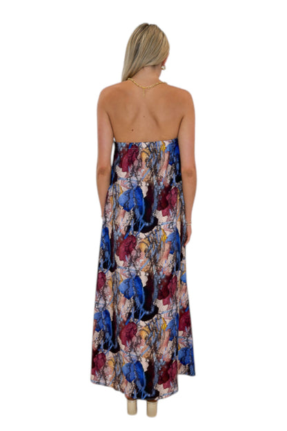 Back view of woman wearing Swagger Boutique’s Multi Snake Print Strapless Maxi Dress with heels against white studio background.