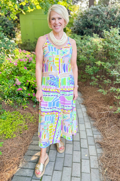 Front view of woman wearing Swagger Boutique’s Multi Tropical Print Maxi Dress with sandals walking outside.
