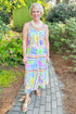 Front view of woman wearing Swagger Boutique’s Multi Tropical Print Maxi Dress with sandals walking outside.