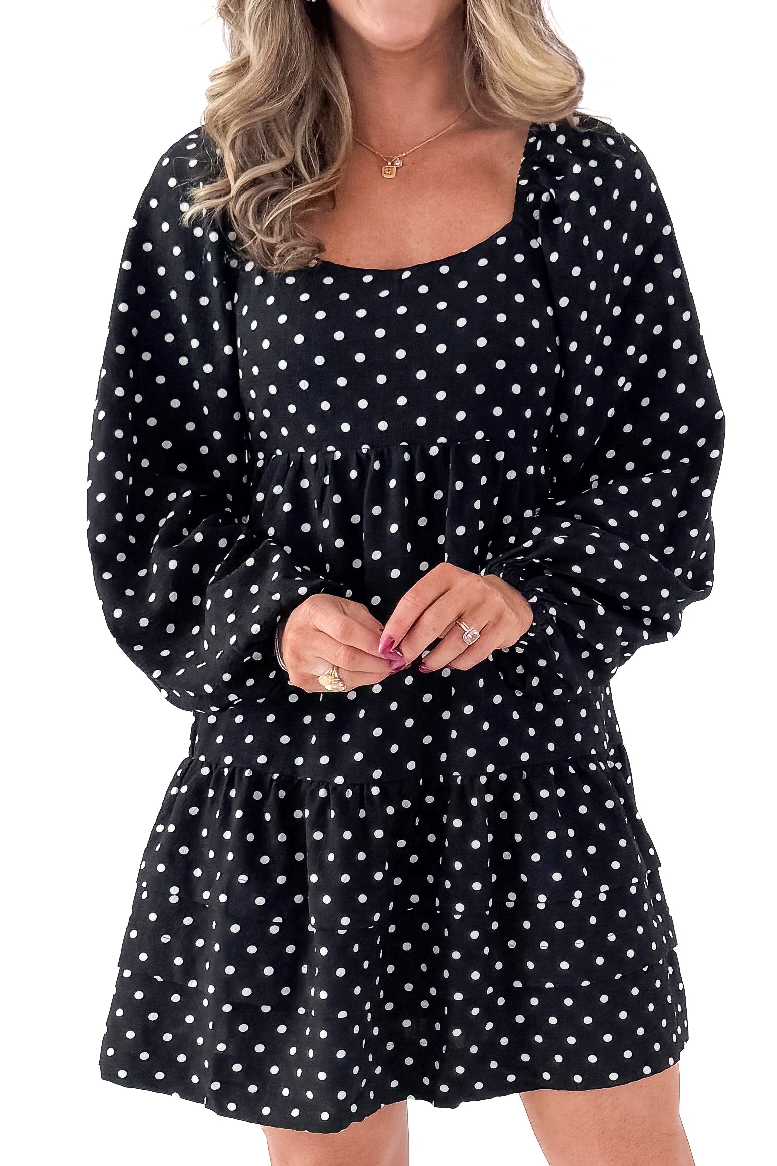 Front detailed view of woman wearing polka dot dress and boots against white studio background.