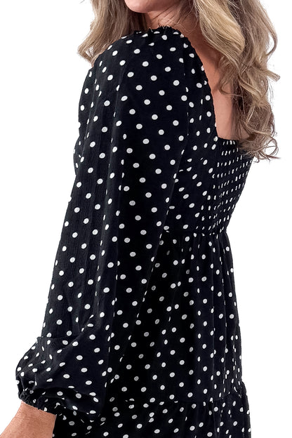 Side view of woman wearing polka dot dress and boots against white studio background.