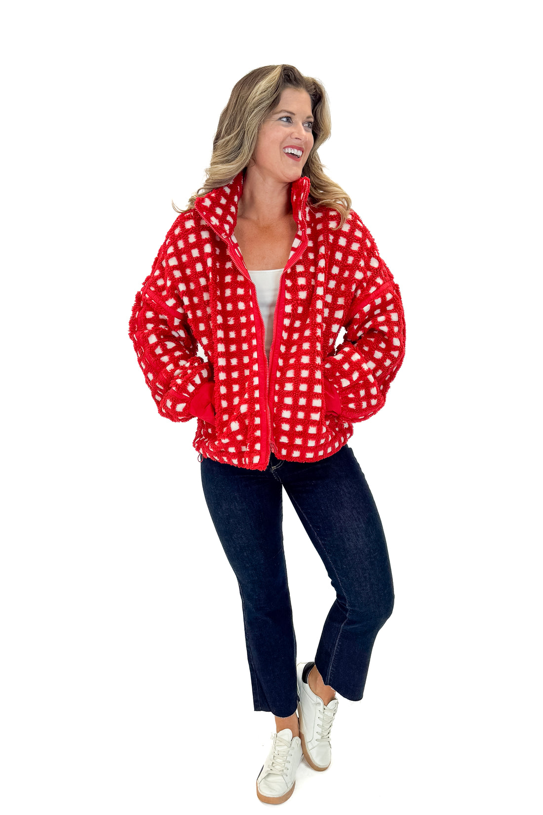 Front view of woman wearing Red &amp; Cream Checkered Sherpa Jacket with jeans against white studio background.