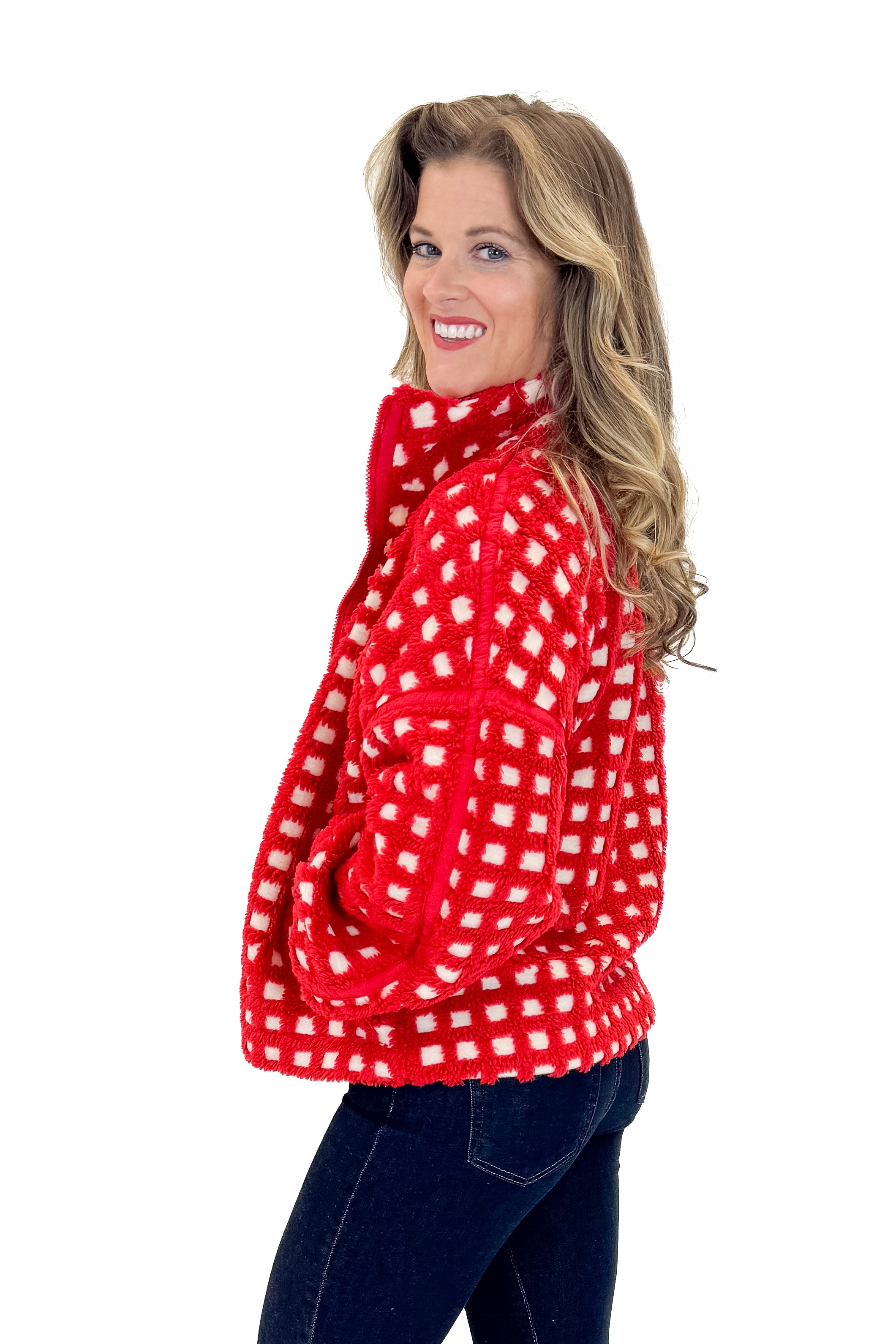 Side view of woman wearing Red &amp; Cream Checkered Sherpa Jacket with jeans against white studio background.