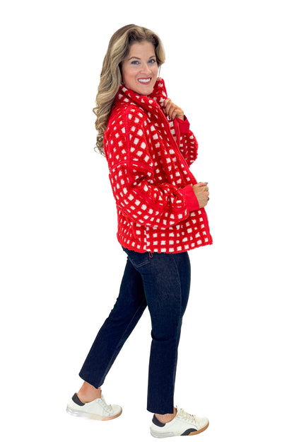 Side view of woman wearing Red &amp; Cream Checkered Sherpa Jacket with jeans against white studio background.
