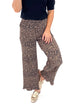Front view of woman wearing Leopard Pleated Pants with sweater against white studio background.