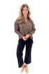 Front view of woman wearing Leopard Pleated Button Up Top with jeans against white studio background.