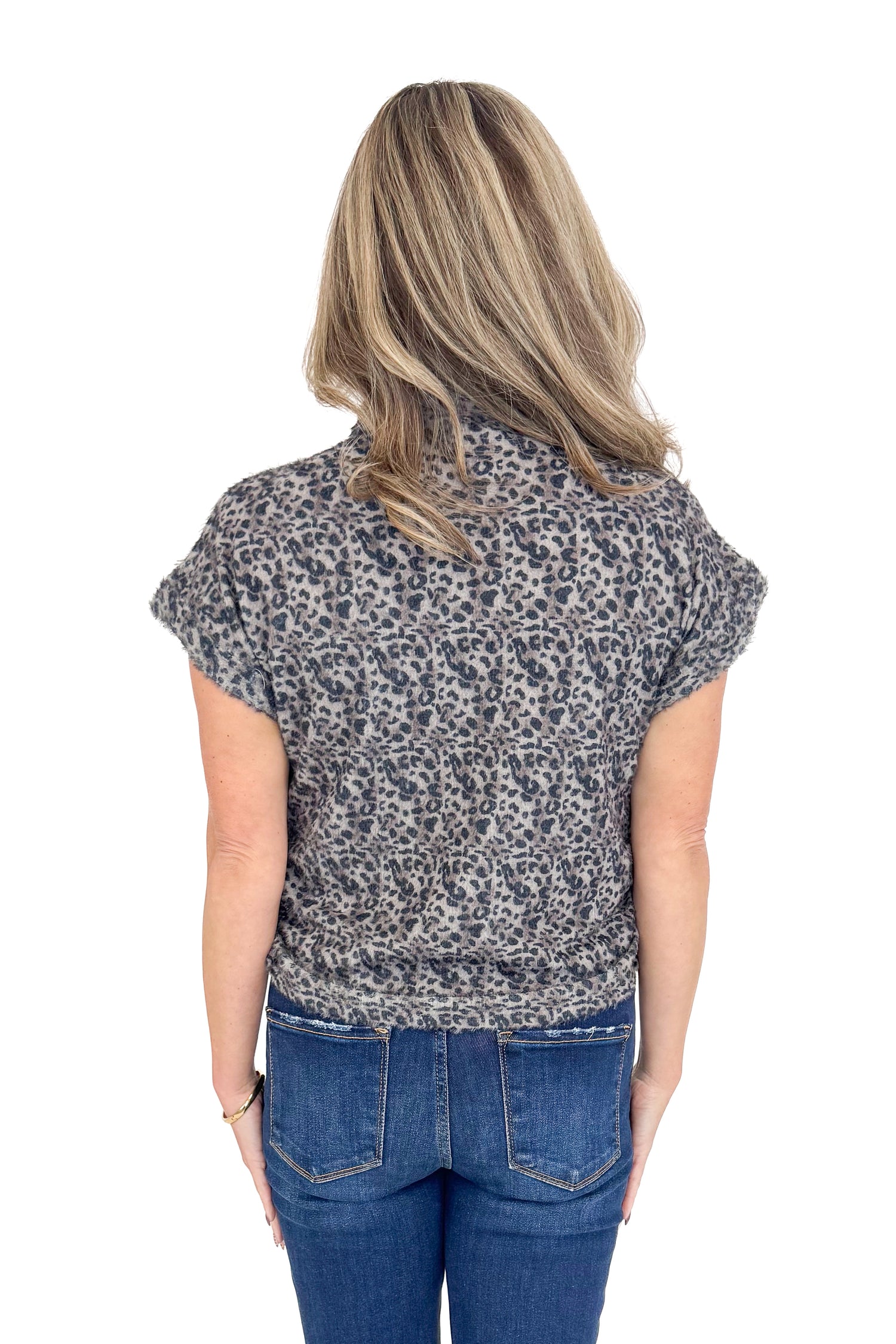 Back view of woman wearing Grey Leopard Short Sleeve Fuzzy Top and blue jeans. 