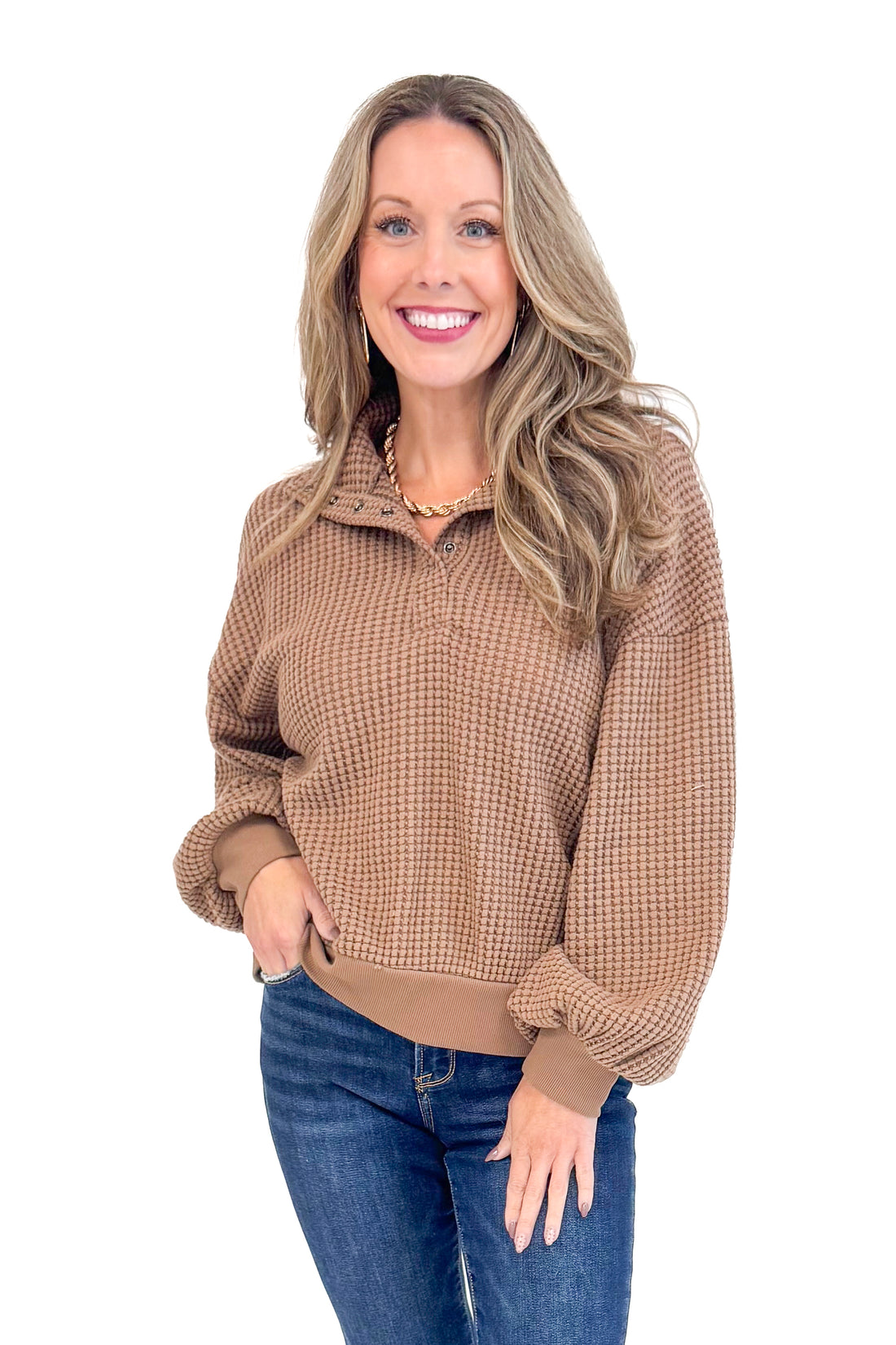 Studio picture of woman wearing Chocolate Waffle Knit Button Detail Top and jeans with a white background.