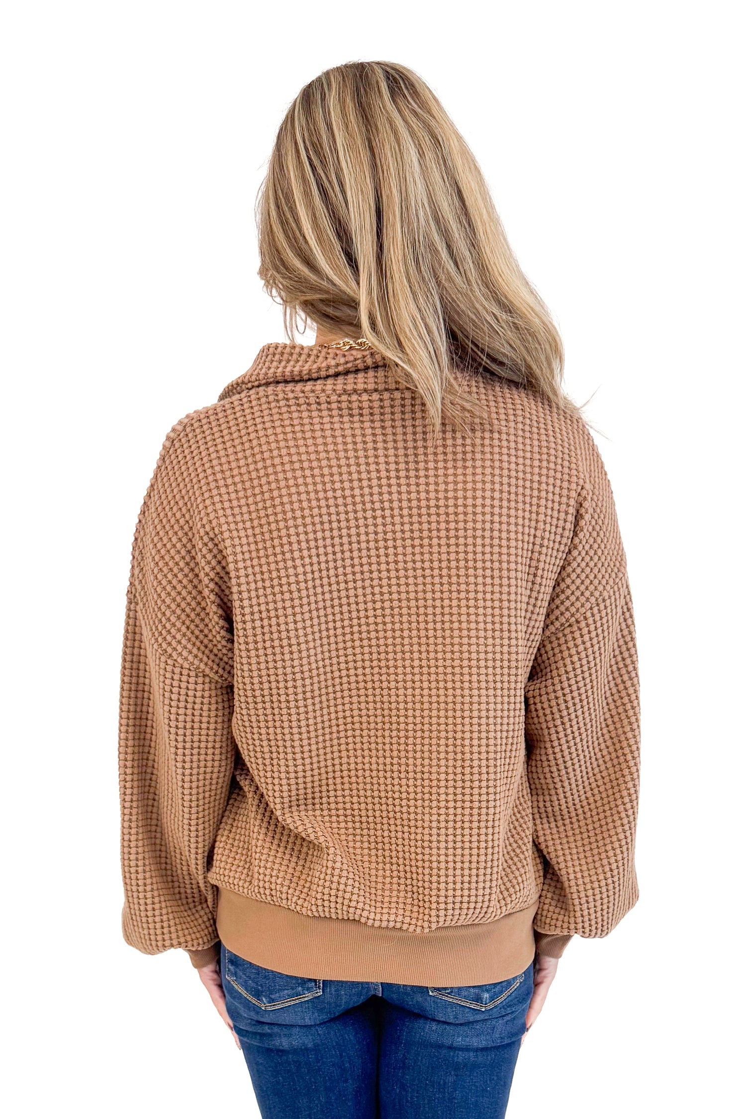 Back view of woman wearing Chocolate Waffle Knit Button Detail Top and jeans with a white background. 