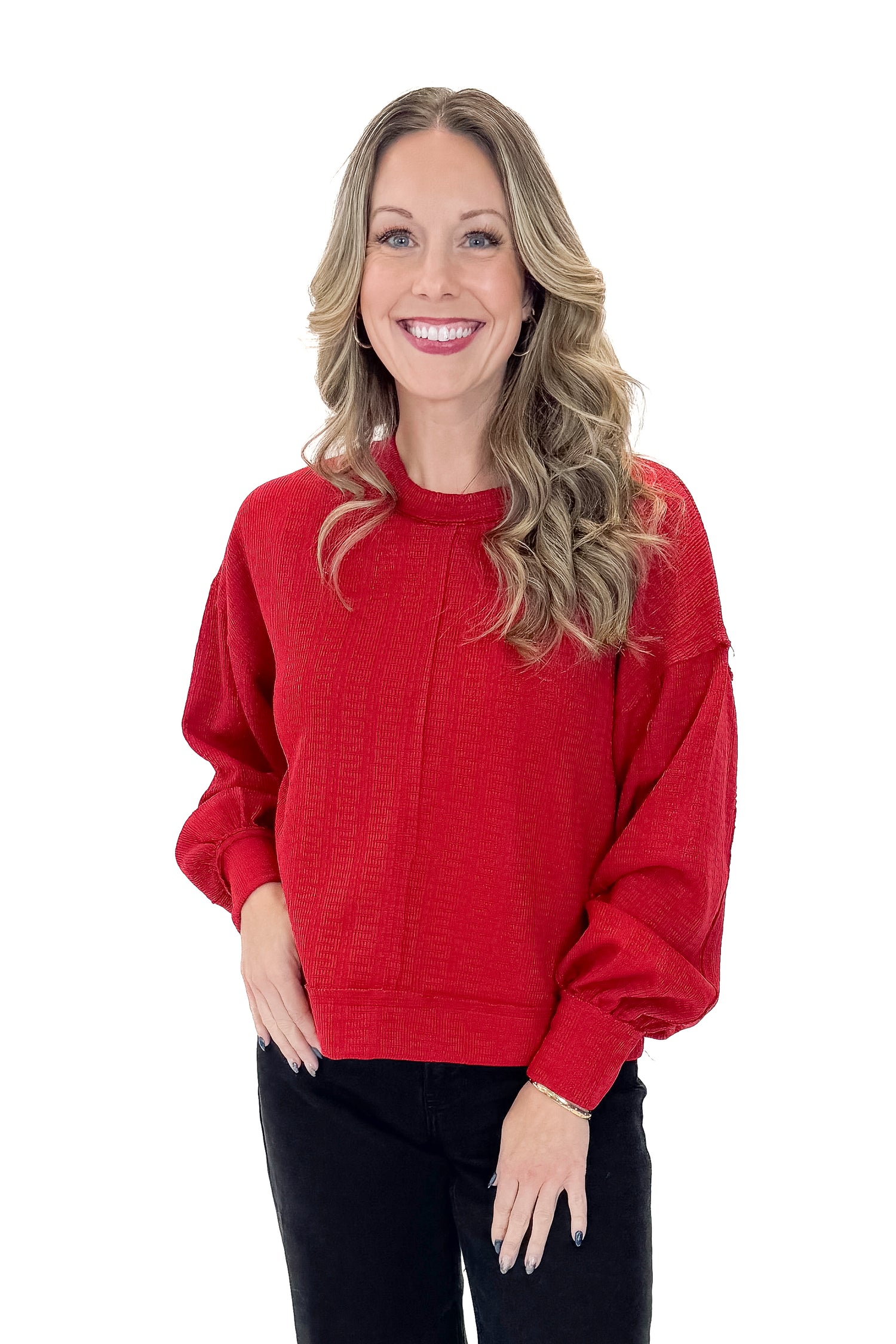 Front view of woman wearing Red Center Seam Textured Top with jeans against white studio background.