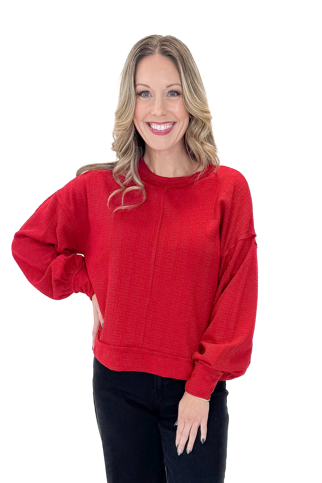 Front view of woman wearing Red Center Seam Textured Top with jeans against white studio background.