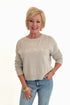 Front view of woman wearing Swagger Boutique’s Natural Heather Beach Embroidered Sweater by Z Supply with jeans against white studio background.