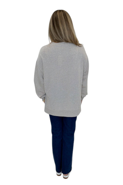 Back view of woman wearing Swagger Boutique’s Natural Heather Modern Weekender by Z Supply with jeans against white studio background.
