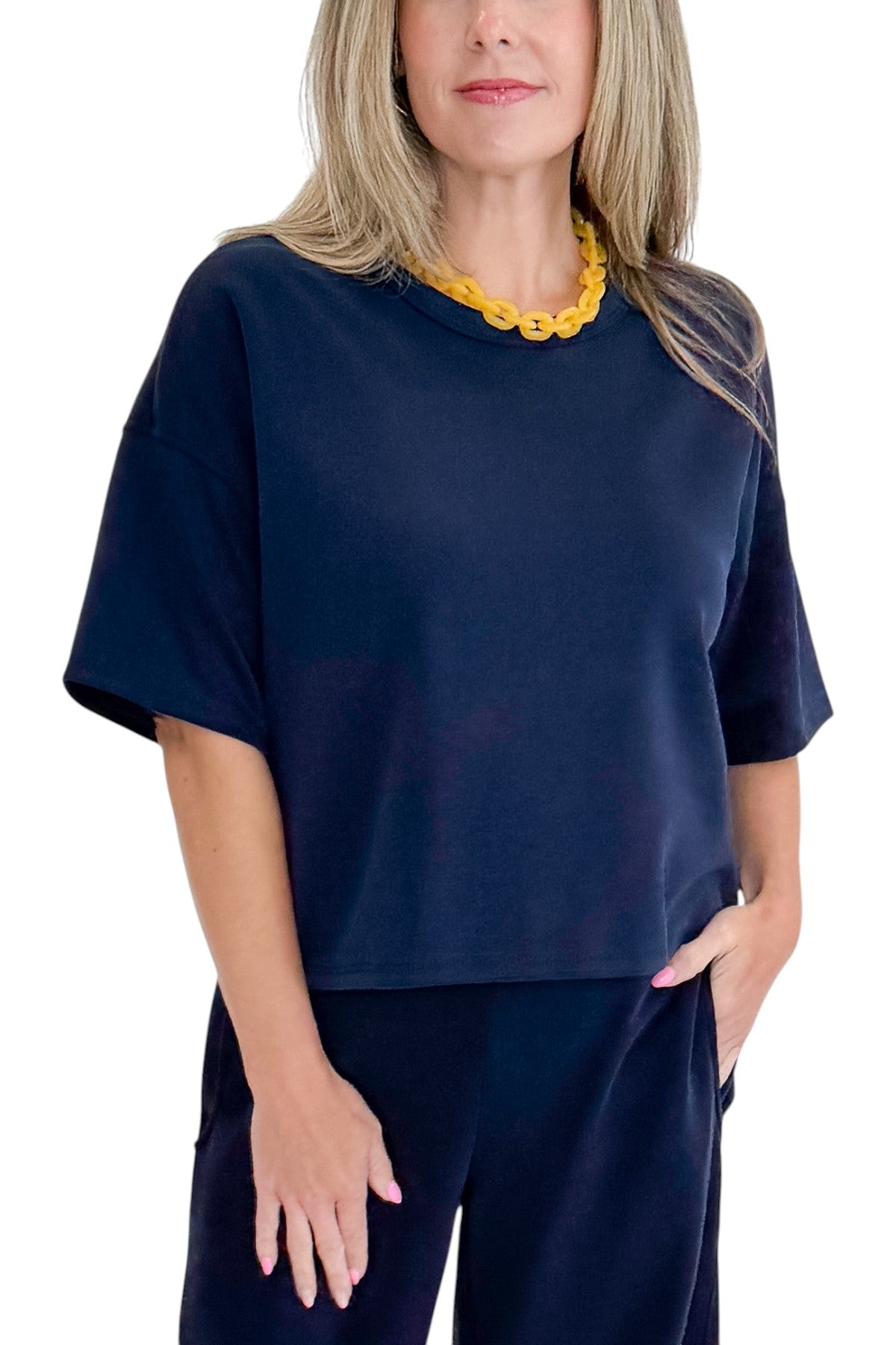 Front detail view of woman wearing Swagger Boutique’s Navy Barrel Lounge Pants with Navy Round Neck Short Sleeve Top against white studio background.
